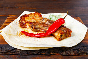 Delicious grilled meat served on a tortilla with fresh chili peppers Savory vegetable pie served with fresh garnishes on a white plate
