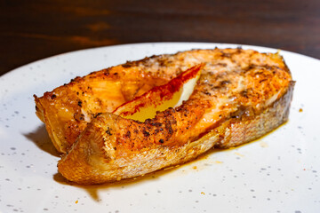 Delicious grilled salmon steak served on a white plate with herbs Savory vegetable pie served with fresh garnishes on a white plate