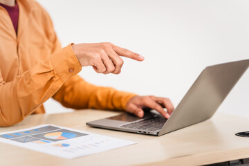 A businessman sitting at a desk in an office, using a laptop, representing accounting, finance,business planning, managing financial data,strategizing business growth,overseeing financial operations