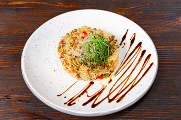 Creative presentation of colorful vegetable rice dish on a white plate Savory vegetable pie served with fresh garnishes on a white plate