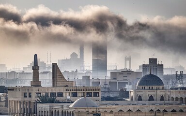 Fototapeta premium Iraq air pollution, Cityscape shrouded in industrial smog at dawn.