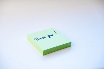Green note stickers with the inscription Thank you on a light background.