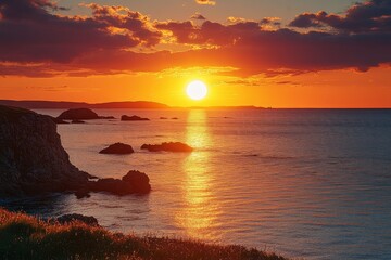 Setting sun casts an orange glow over the sea, illuminating rock silhouettes and distant islands, dramatic coastal scene.
