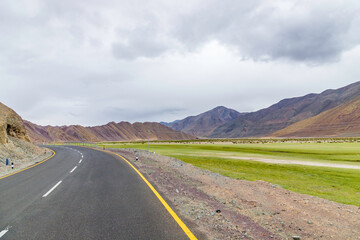 Empty road in wilderness area, in Nyoma Village with Indus river, in Ladakh, India.