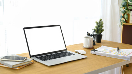 Fototapeta premium Modern workspace with a laptop, smartphone, and business paperwork on wooden desk