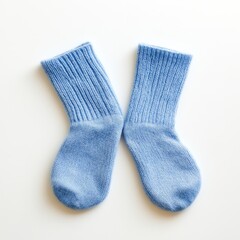 Pair of light blue, knitted cotton socks on white background.