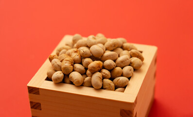 Japanese event, Setsubun. Soybeans for bean-sowing placed on a red background. 日本の行事。節分。赤背景上に置かれた豆まき用の大豆。