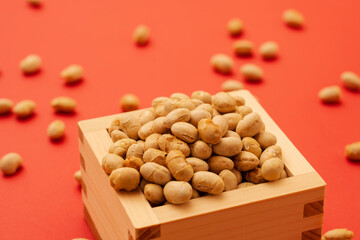 Japanese event, Setsubun. Soybeans for bean-sowing placed on a red background. 日本の行事。節分。赤背景上に置かれた豆まき用の大豆。