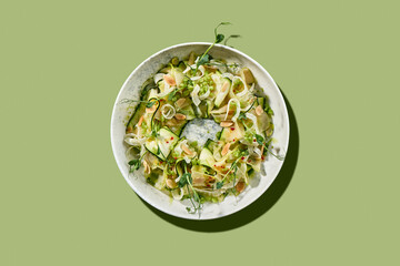 A vibrant and refreshing salad featuring thinly sliced zucchini noodles, fresh peas, and a drizzle of creamy dressing.