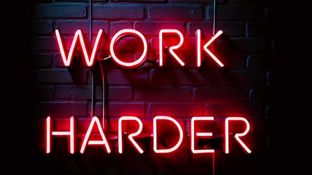 Neon sign displaying the motivational phrase "WORK HARDER" against a dark brick background.