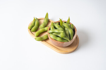 Edamame beans in wooden tray and bowl