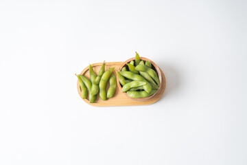 Edamame beans in wooden tray and bowl