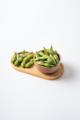 Edamame beans in wooden tray and bowl