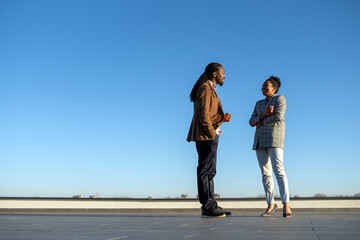 Happy business colleagues enjoying on coffee break and having fun while talking on a balcony