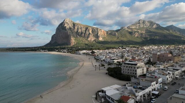 Aerial view of beautiful long beach in San Vito Lo Capo, with rugged mountain scenery in the background. Popular tourist destination in Sicily Italy.
