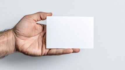 Hand holding blank card, simple background, mockup design