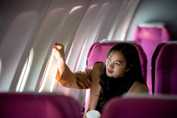 Professional female working, adjusting window shade during flight