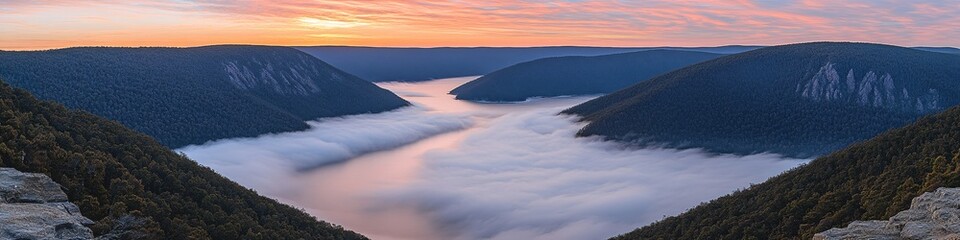 Obraz premium Misty Valley at Dawn with Pink Sky and Mountain Peaks Overlooking a Foggy River