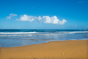 Cyprus Alagadi Turtle Beach. View from the beach to the sea. Magnificent beach, sea and blue cloudy sky. Yellow sand beach. Beach and blue sky.
