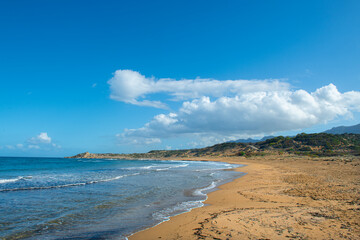 Cyprus Alagadi Turtle Beach. View from the beach to the sea. Magnificent beach, sea and blue cloudy sky. Yellow sand beach. Beach and blue sky.
