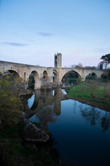 Medieval stone bridge leading to picturesque village in catalonia