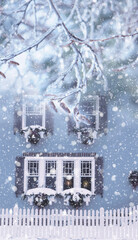 house with shutters decorated with christmas wreaths and house with shutters decorated with christmas wreaths and candles and branches in snow and frost. falling snow magical winter atmosphere of wint