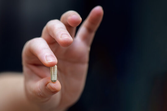 woman's hand holding a chelated iron capsule, designed to boost hemoglobin levels. Ideal for health, nutrition, and wellness themes