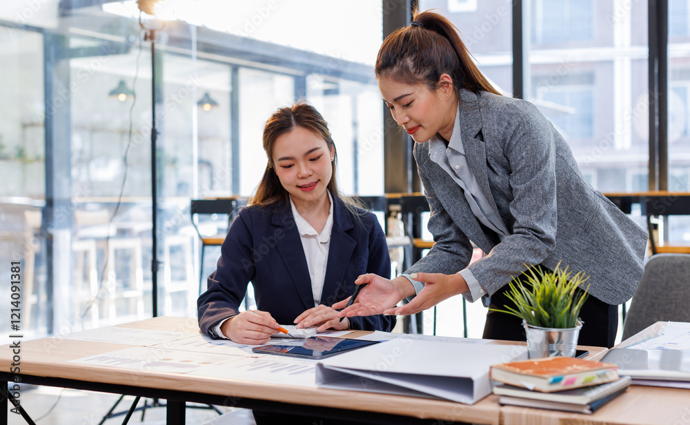 Wall mural Two happy business asian women coworking with a laptop in a desktop at office.Freelance mobile office business concept.