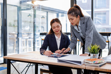 Two happy business asian women coworking with a laptop in a desktop at office.Freelance mobile office business concept.