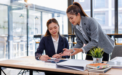 Two happy business asian women coworking with a laptop in a desktop at office.Freelance mobile office business concept.