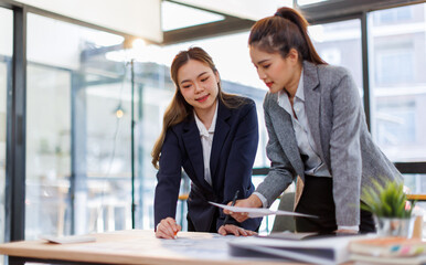 Two happy business asian women coworking with a laptop in a desktop at office.Freelance mobile office business concept.
