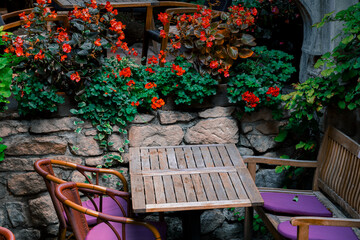 Obraz premium old Europe vintage aesthetic of patio rustic restaurant wooden furniture and blossom flowers garden floral design landscaped space
