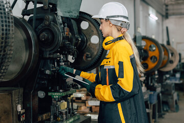 professional engineer caucasian women inspecting auditing old machine in heavy industry factory