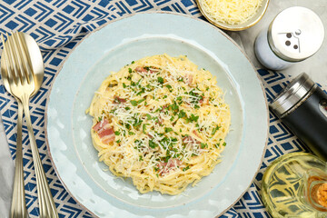 Delicious pasta Carbonara with bacon served on gray textured table, flat lay