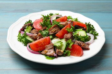 Delicious fresh tuna salad on light blue wooden table, closeup
