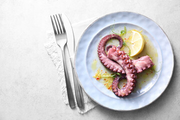 Appetizing octopus tentacles served on light table, top view © New Africa