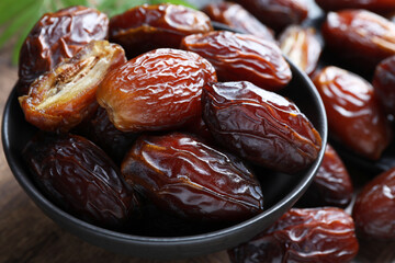 Tasty dried dates in bowl on table, closeup