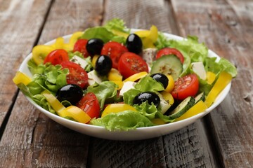 Delicious fresh Greek salad on wooden table, closeup