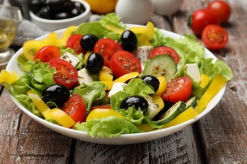 Delicious fresh Greek salad on wooden table, closeup