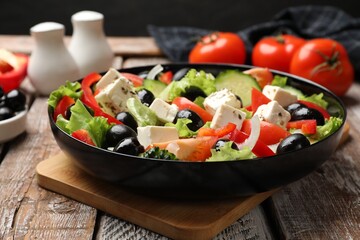 Delicious fresh Greek salad on wooden table, closeup