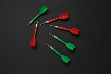 Colorful dart arrows on black background, flat lay