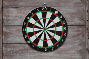One dart board hanging on wooden rustic background