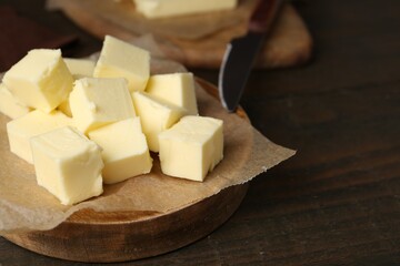 Pieces of fresh butter on wooden table, closeup. Space for text
