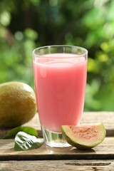 Refreshing guava juice and fresh fruits on wooden table, closeup