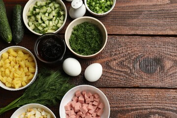 Different ingredients for okroshka soup on wooden table, flat lay. Space for text