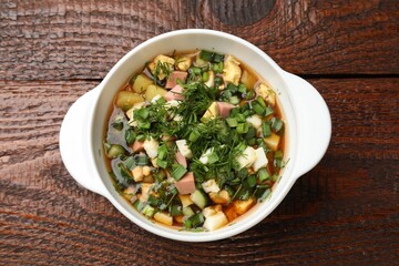 Delicious okroshka soup on wooden table, top view