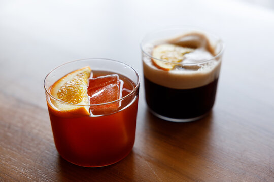 Cup of creation coffee Mocktail drink decorated with orange on wooden table.