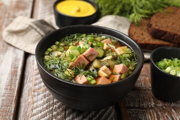 Delicious okroshka soup with kvass and ingredients on wooden table, closeup