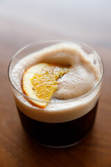 Cup of creation coffee Mocktail drink decorated with orange on wooden table.