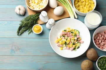 Ingredients for okroshka soup on light blue wooden table, flat lay. Space for text